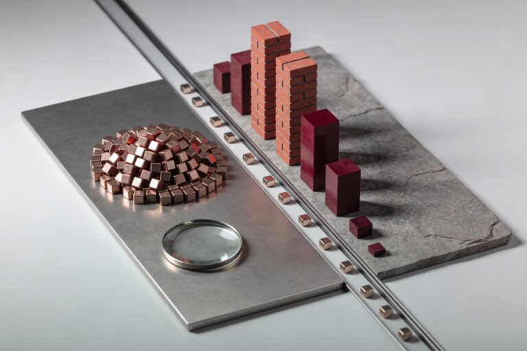 Maquette physique montrant une plaque métallique divisée entre un bloc compact de cubes représentant un ETF actions cap-pondéré et plusieurs colonnes de blocs smart beta, avec des jetons rouges de flux qui s’accumulent dans une seule zone, symbolisant le risque de concentration caché lorsque les ETF smart beta attirent des flux massifs en 2025