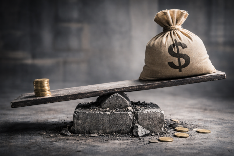 Planche en équilibre instable sur un socle fissuré, avec un sac lourd d’un côté et une petite pile de pièces de l’autre